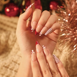 Christmas almond false nails with French red edges and candy cane stripe patterns