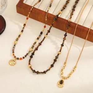 Retro beaded necklaces with sun pendant and tiger eye stones on a wooden tray