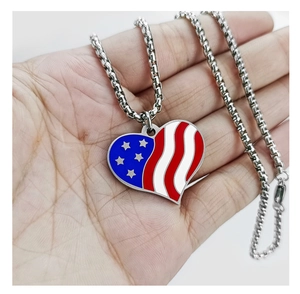 Detail of a stainless steel heart necklace with American flag patterns in a hand