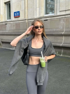 Outdoor shot of a women's three-piece activewear set in dark grey washed-out fabric