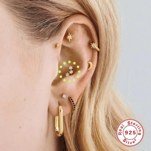 Macro view of gold S925 sterling silver stud earrings set shown on model's ear