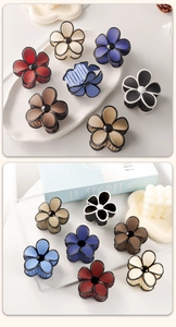 Detailed close-up of matte rubber paint floral hair claws in various autumn colors