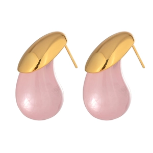 Detail of pink teardrop earrings with gold metal tops and glossy finish on white surface