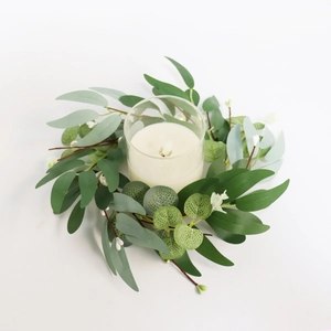 Close-up of 30cm eucalyptus candle ring with glass holder and white floral accents