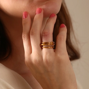 Detail of 18K gold-plated four-layer stacked ring with pavé-set shimmering zircon stones