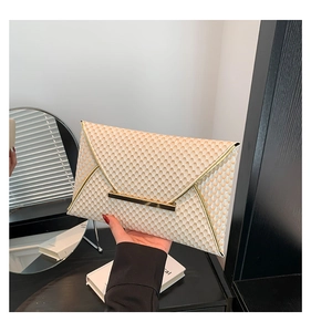 Dettaglio della pochette a busta bianco crema con finitura testurizzata e bordo dorato