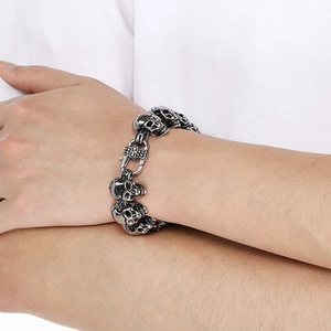 Detail of man wearing a silver skull link bracelet made of stainless steel on wrist