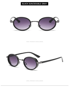 Close-up of black gunmetal oval sunglasses with gradient gray lenses and metal frames