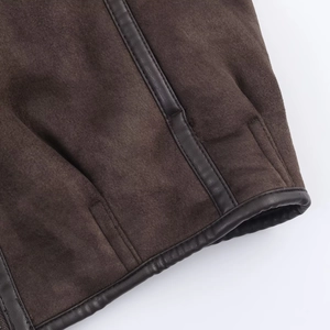 Detailed close-up of dark brown suede jacket with high-quality leather piping and stitching