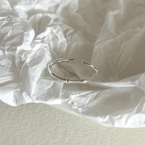 Macro detail of silver bamboo joint open ring on a minimalist aesthetic background