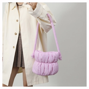 Detail of mauve padded puffer bag showing soft quilted nylon texture and gathered folds