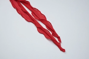 Détail de la texture en maille rouge et de la finition volantée sur le haut d'hiver