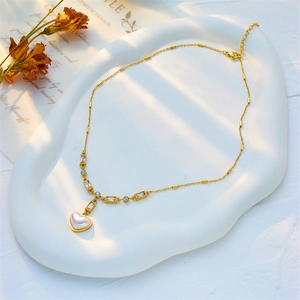 Vintage heart pearl pendant necklace in gold titanium steel on a white cloud tray