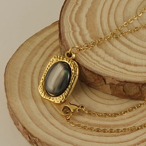 Golden titanium steel necklace with tiger eye pendant on a natural wood aesthetic background