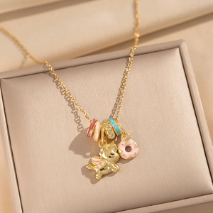 Gold unicorn necklace with flying pig and donut pendants on premium velvet box