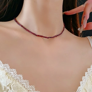 Détail du collier à perles rouge foncé sur le cou d'un mannequin, style bohème