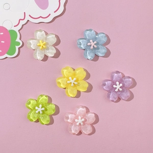 Set of six colorful resin cherry blossom charms for DIY crafts on a pink background