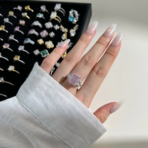 Close-up of luxury 925 silver ring with radiant pink ice cut zircon on a finger