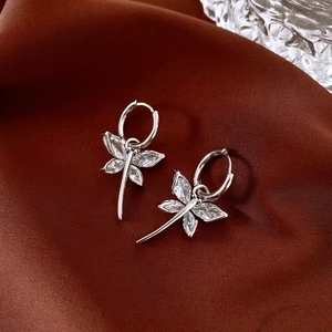 Silver butterfly fringe hoop earrings with zircons on elegant dark brown silk background