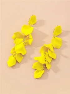 Détails des boucles d'oreilles longues à pétales jaunes sur fond rose doux