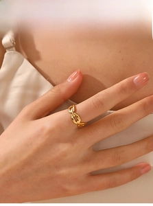 Detailed close-up of 18K gold-plated Cuban link chain ring worn on a woman's finger
