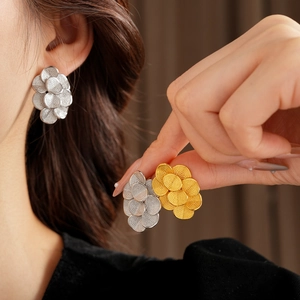 Détail de boucles d'oreilles fleur plaquées or 18K montrant le design de disques empilés
