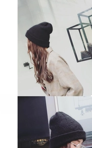 Close-up of black knitted beanie with fine wool texture and elastic cuff detail