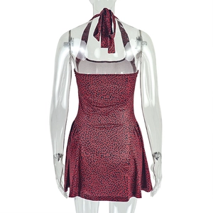 Detail of red and black floral print dress featuring halter neck tie and open back design