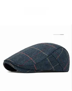 Detail of navy herringbone wool blend flat cap featuring red and yellow plaid patterns