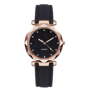 Detail of rose gold faceted glass quartz watch with black starry dial and leather strap