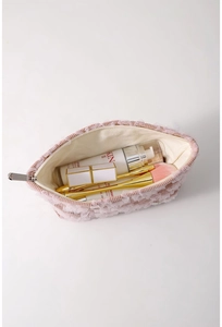 Detail of pink corduroy makeup bag interior showing large storage capacity for skincare