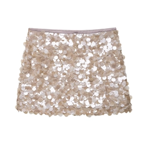 Detailed macro view of champagne sequin fabric and stitching on an A-line mini skirt