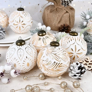 Detail of white 8cm Christmas ball with golden embossed patterns and antique metal cap
