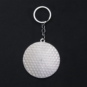 Macro view of silver metal mood tracker keychain with intricate geometric texture detailing