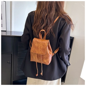 Detail of vintage caramel brown backpack with drawstring and textured PU leather