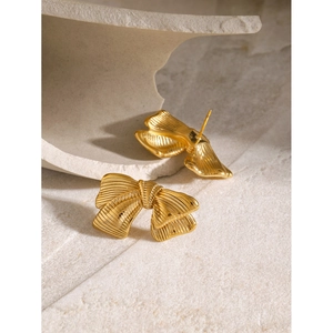 Close-up of 18k gold plated stainless steel bow earrings with brushed metal texture