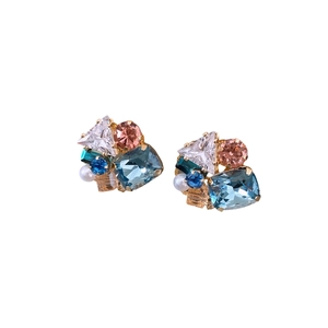 Elegant gold earrings featuring geometric crystals and pearls on a white background