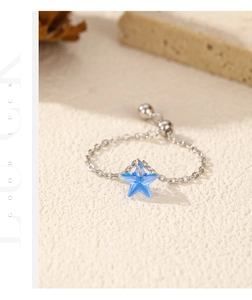 Close-up of S925 silver chain ring featuring a dangling blue star crystal and beads