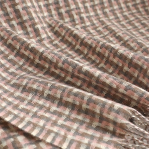 Close-up of soft plaid cashmere-feel fabric with pink, brown, and beige woven fibers