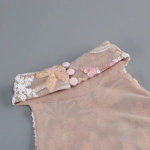Dettaglio dell'abito rosa con ricami di paillettes e bottoni sul colletto alto