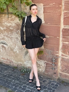 Elegante abito a pois nero con colletto polo in chiffon e maniche lunghe con balze morbide