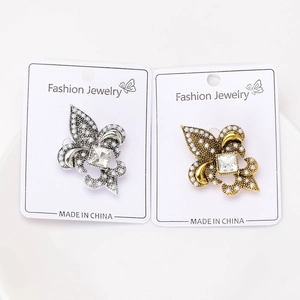 Vue détaillée des broches fleur de lys vintage avec perles et cristaux
