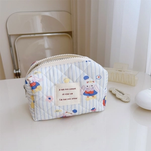 Détail d'une pochette en coton matelassé aux rayures bleues et motifs de lapins