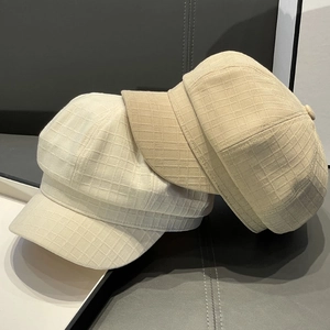 Detailed texture of striped newsboy caps in beige and khaki with woven grid fabric