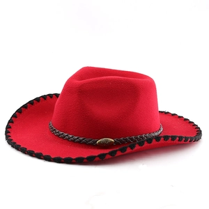 Detail of red wool felt cowboy hat with black stitched brim and bull metal ornament
