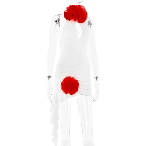 Detailansicht eines weißen Neckholder-Kleides mit roten Blumenakzenten und Rüschensaum