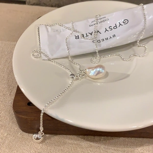 Pendentif perle baroque sur chaîne à billes argentée dans un décor de style élégant