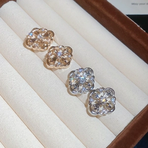 Detail showing gold and silver hollow clover stud earrings with sparkling white zircons