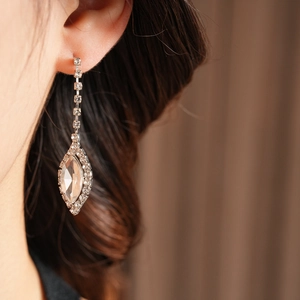 Close-up of elegant silver tassel earrings with clear rhinestones on a female model