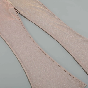 Close-up of rose gold flare pants showing metallic glitter fabric and fine ribbed texture